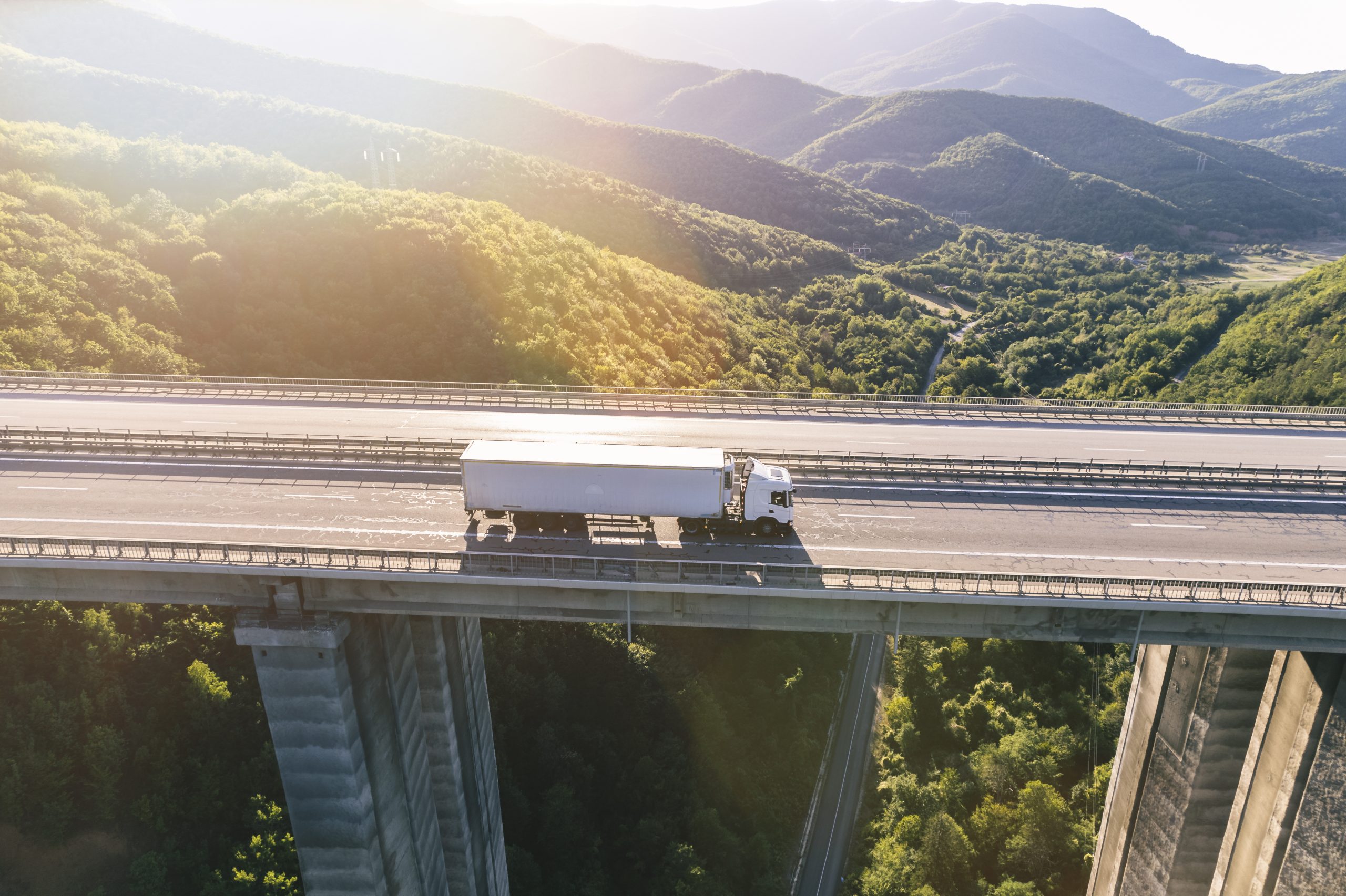 trucks on highway in mountain at sunset