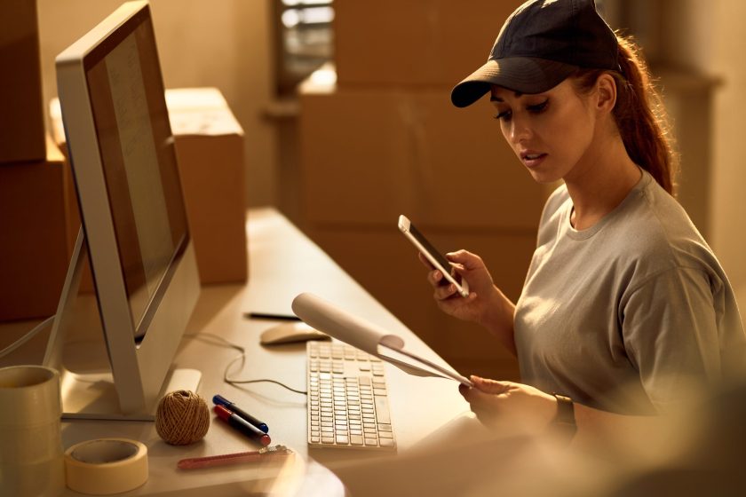 Female courier going through paperwork while working in the offi